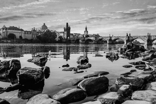 Kampování - Pohled na Karlův most od břehu Kampy za soumraku, s odrazy mostu a oblohy ve vodě, autor Martin Lukač