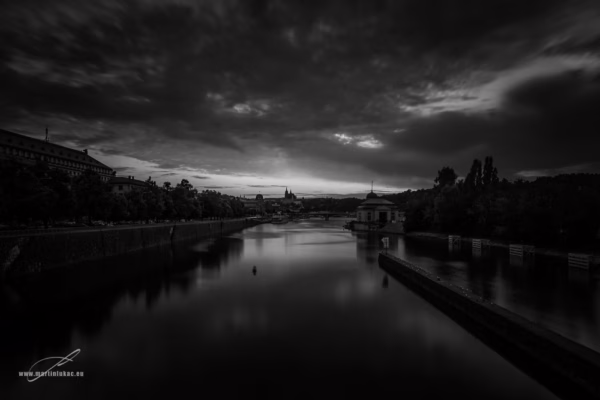 Dramatický pohled na Vltavu a Prahu v černobílém provedení s temným nebem, autor Martin Lukač, pražský fotograf, www.martinlukac.eu