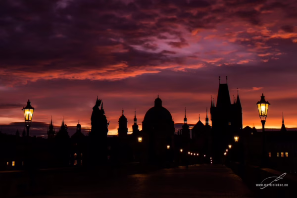Karlův most za svítání s fialovo-oranžovou oblohou a siluetami soch, autor Martin Lukač, pražský fotograf, www.martinlukac.eu