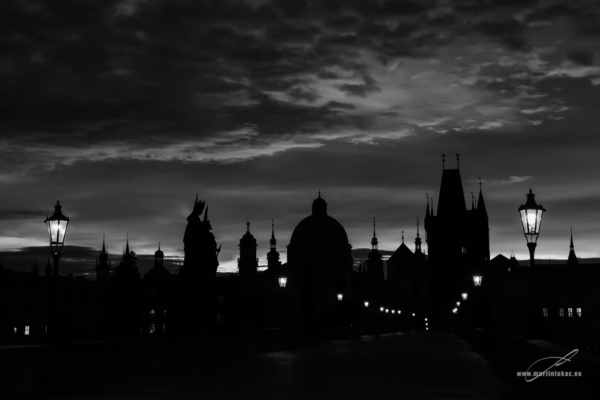 Černobílá verze fotografie Karlova mostu za svítání, siluety soch a věží, autor Martin Lukač, pražský fotograf, www.martinlukac.eu
