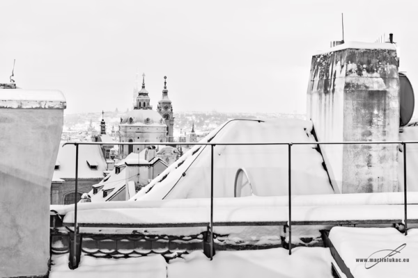 Černobílá verze výhledu na zasněžené střechy Prahy s věžemi v pozadí, autor Martin Lukač, pražský fotograf, martinlukac.eu