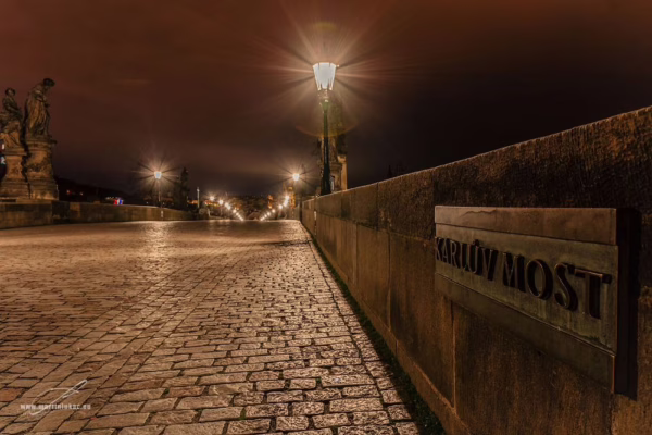 Noční pohled na prázdný Karlův most s cedulí a lampami, autor Martin Lukač, pražský fotograf, www.martinlukac.eu