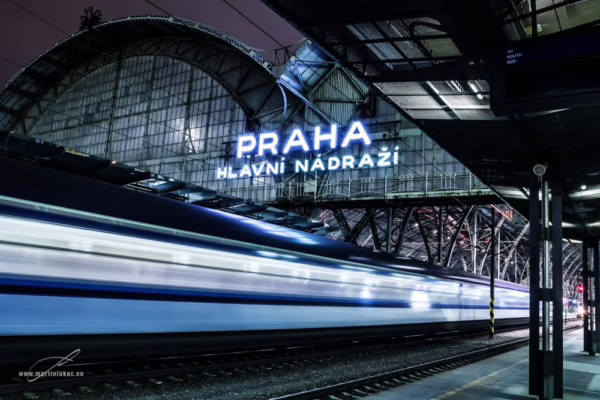 Noční pohled na hlavní nádraží v Praze s rozmazaným projíždějícím vlakem, autor Martin Lukač, pražský fotograf, www.martinlukac.eu