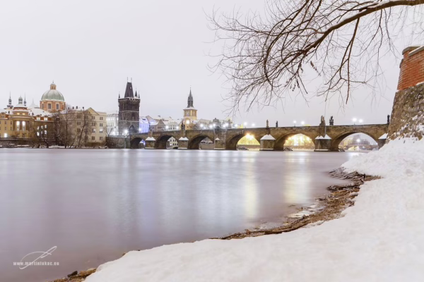 Zimní pohled z Kampy na Karlův most v Praze pokrytý sněhem, autor Martin Lukač, pražský fotograf, www.martinlukac.eu