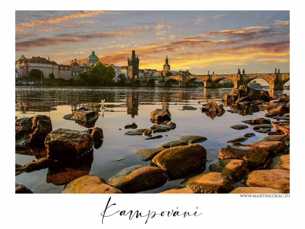 Karlův most za ranního světla od břehu Vltavy mezi kameny, autor Martin Lukač, pražský fotograf, www.martinlukac.eu