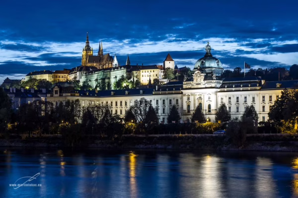 Pražský hrad a Ministerstvo průmyslu osvícené večerním světlem nad Vltavou, autor Martin Lukač, pražský fotograf, www.martinlukac.eu