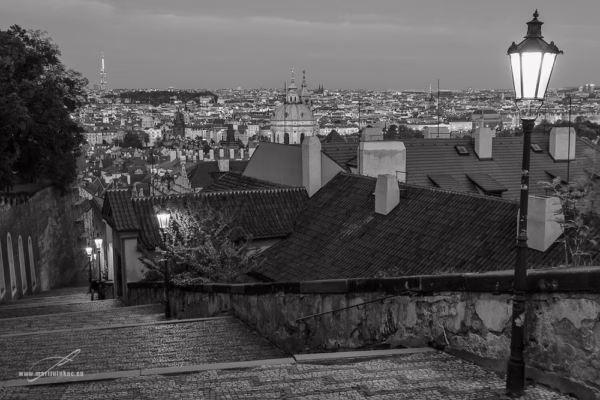 Zámecké schody a panorama Prahy v černobílém večerním záběru, autor Martin Lukač, pražský fotograf, www.martinlukac.eu
