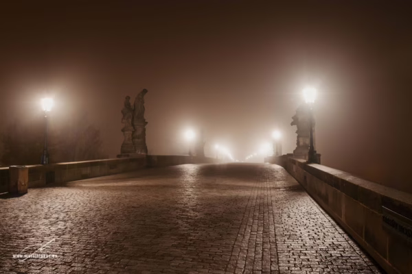 Noční Karlův most zahalený mlhou, osvětlený lucernami, bez lidí, autor Martin Lukač