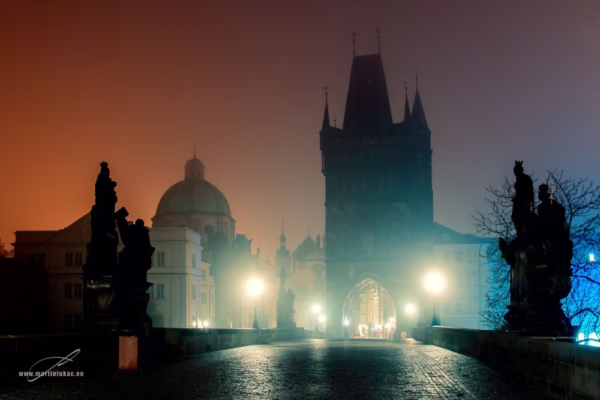 Karlův most s Mosteckou věží v ranní mlze a světlem lamp, autor Martin Lukač