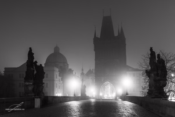 Černobílá verze Karlova mostu s Mosteckou věží zahalenou v mlze, autor Martin Lukač