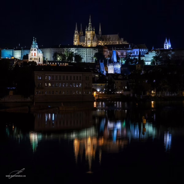 Noční barevně nasvícený Pražský hrad a jeho odraz ve Vltavě, autor Martin Lukač