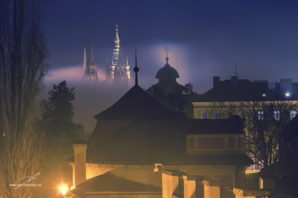 Noční pohled na Pražský hrad s osvícenou katedrálou sv. Víta vystupující z mlhy, autor Martin Lukač