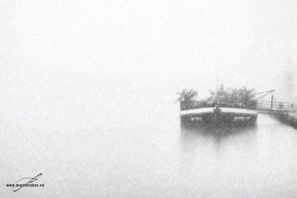 Zajatec v mlze – Loď kotvící v mlze u pražského břehu, černobílá fotografie, autor Martin Lukač, snow art