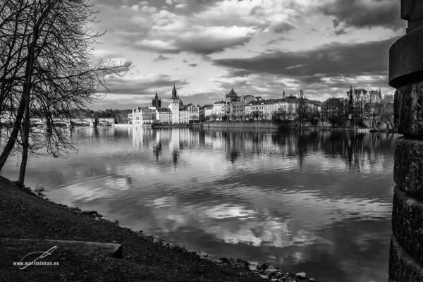 Zrcadlení na Vltavě pod modrou oblohou v černobílé verzi, autor Martin Lukač, pražský fotograf, www.martinlukac.eu