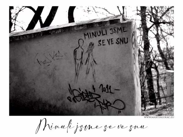 Černobílá fotografie street artu na zdi s nápisem "Minuli jsme se ve snu" a kresbou dvou postav, autor Martin Lukač, pražský fotograf, www.martinlukac.eu